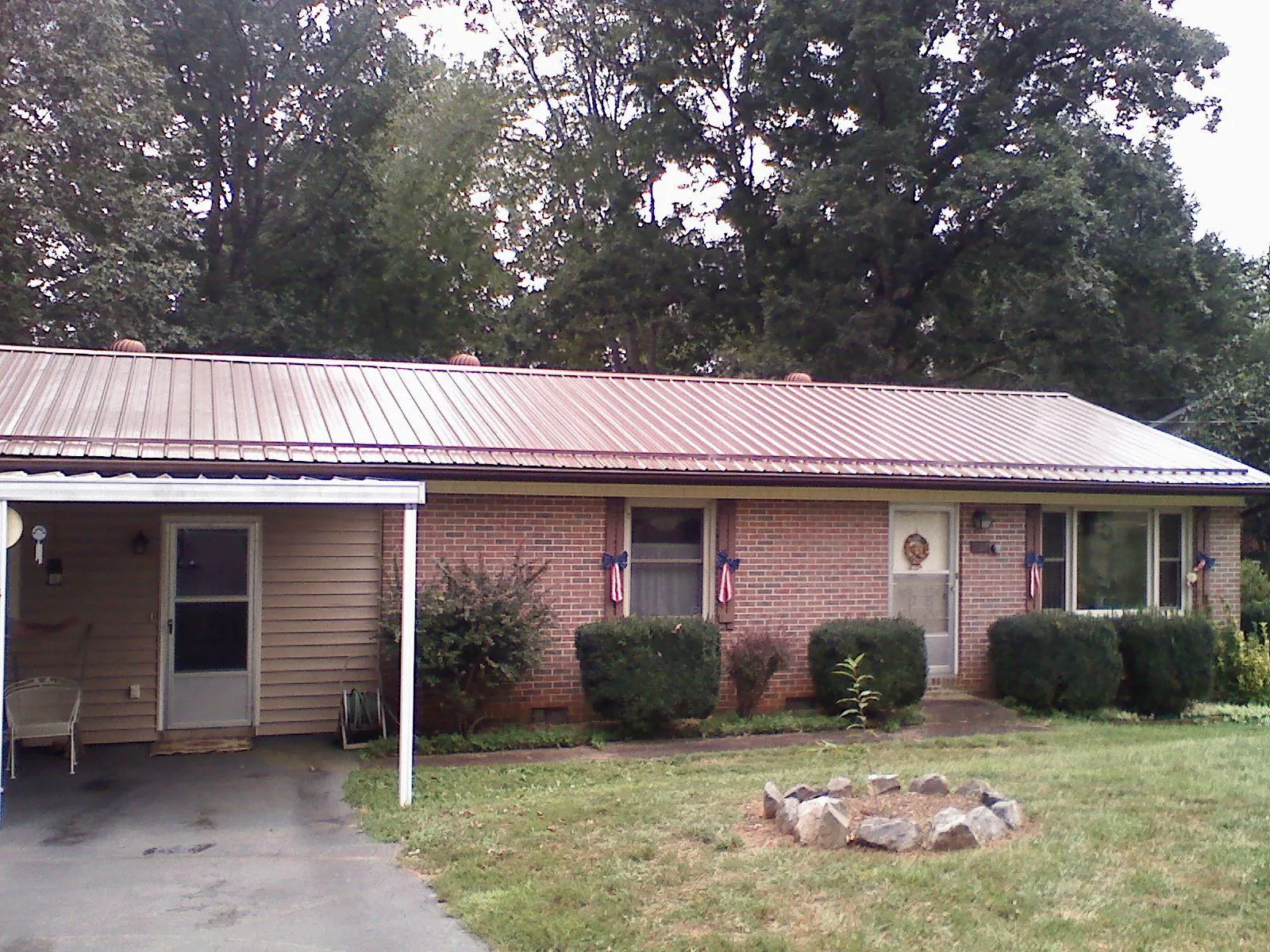 Bronze metal roof and carport on a brick ranch home — Roof Repair work by our crew in Eighty Four